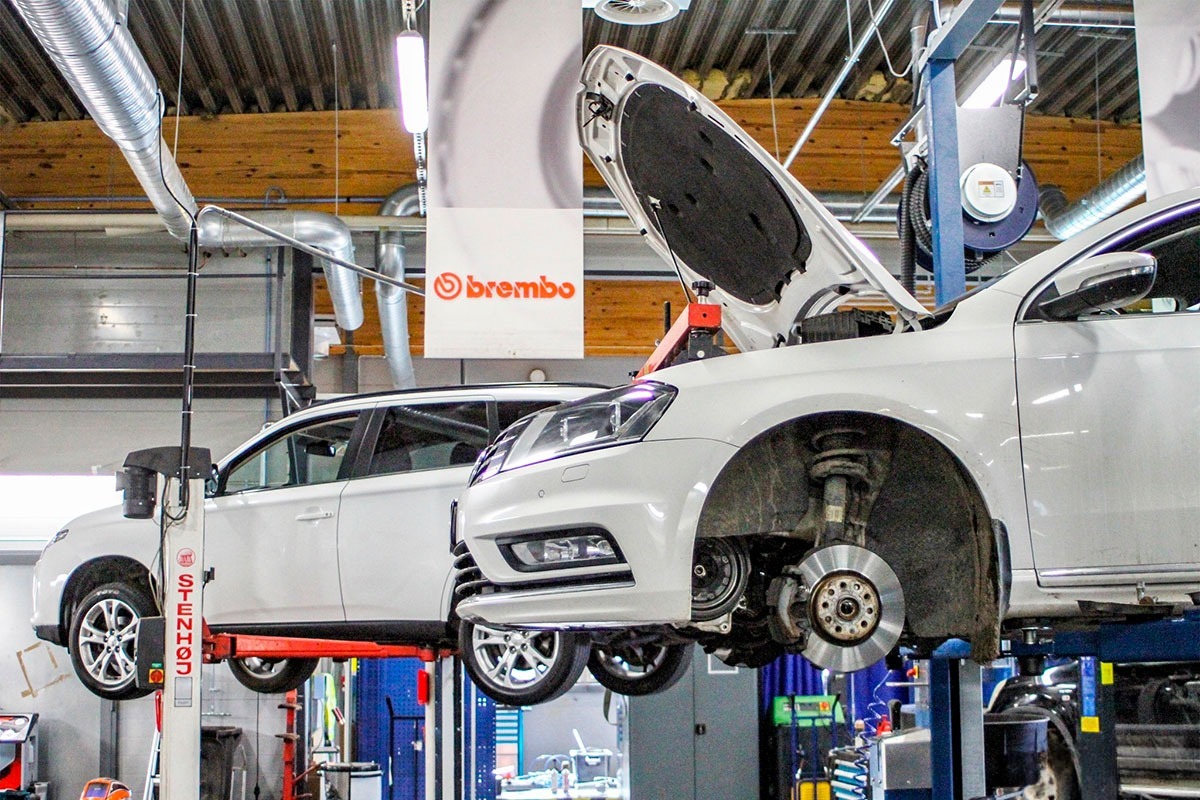 Auton huoltotyö korjaamolla Joensuussa nosturilla